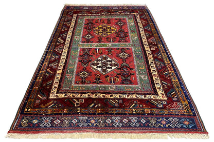 Triangular oriental rug with red pattern, ornamental border and fringes
