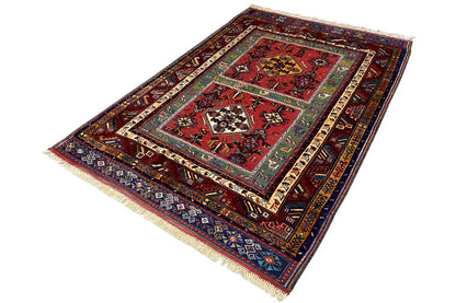 Oriental rug with a red central field, geometric border pattern, and fringes