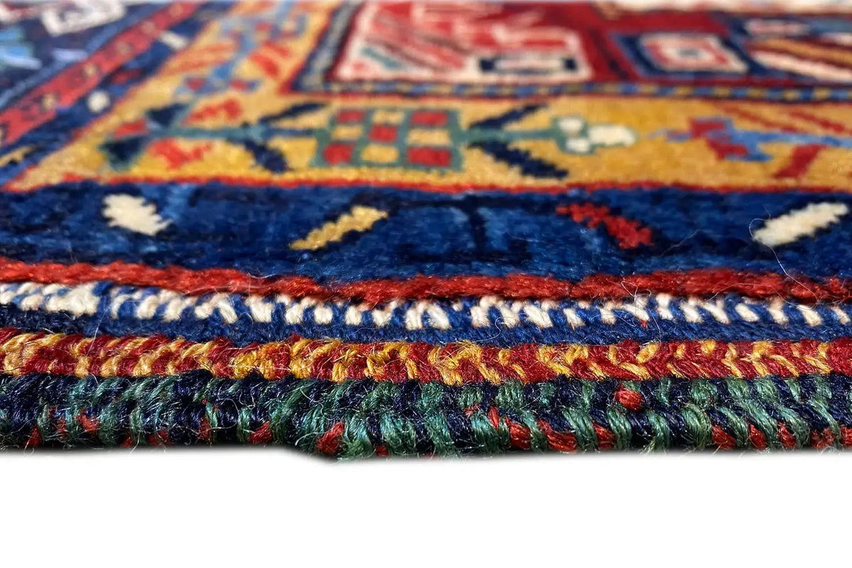 Close-up of a carpet edge with fringe and multicolored border