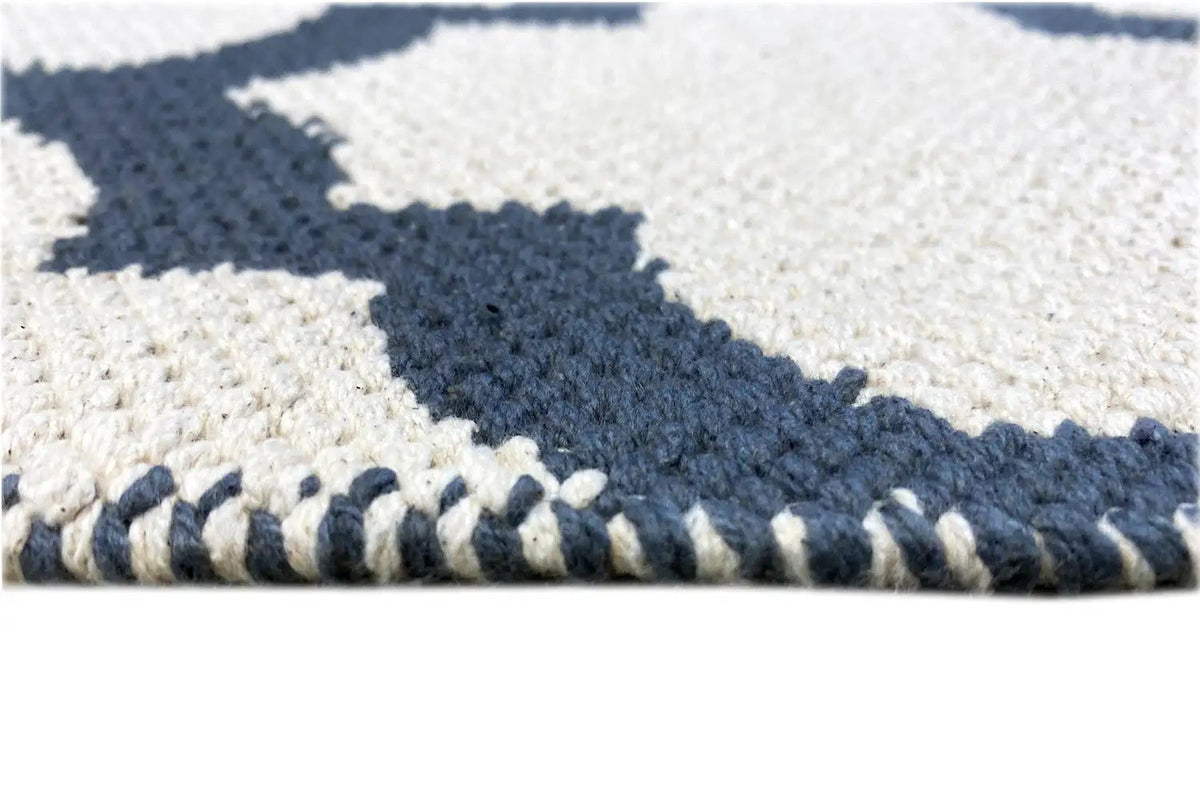 Kilim detail with fringes along the edge and a white/dark blue pattern