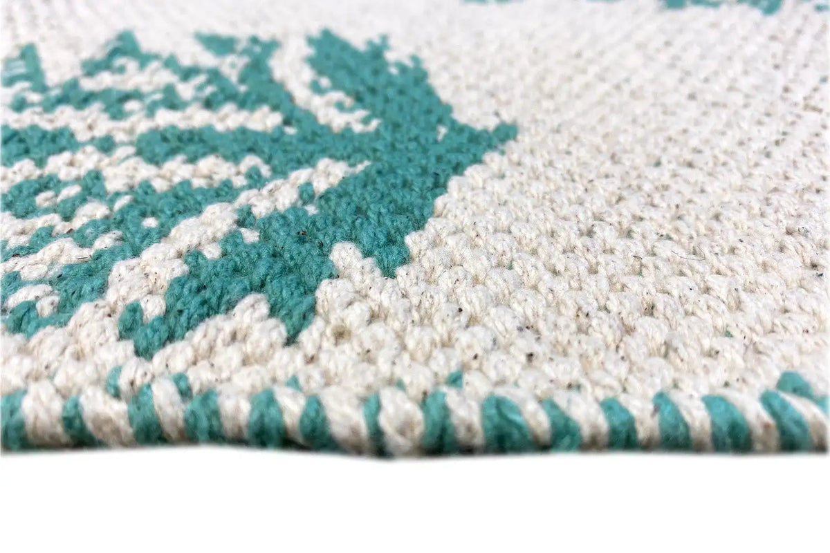 Kilim rug with a green border, woven edge, and all-over pattern