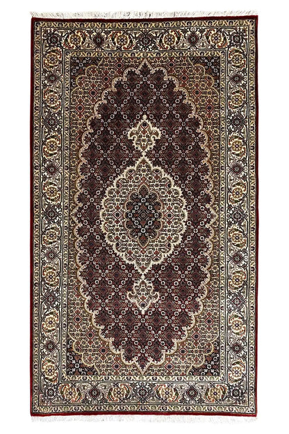Indo-Tabriz rug: rectangular border design with a dark medallion