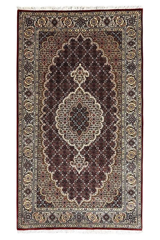 Indo-Tabriz rug: rectangular border design with a dark medallion