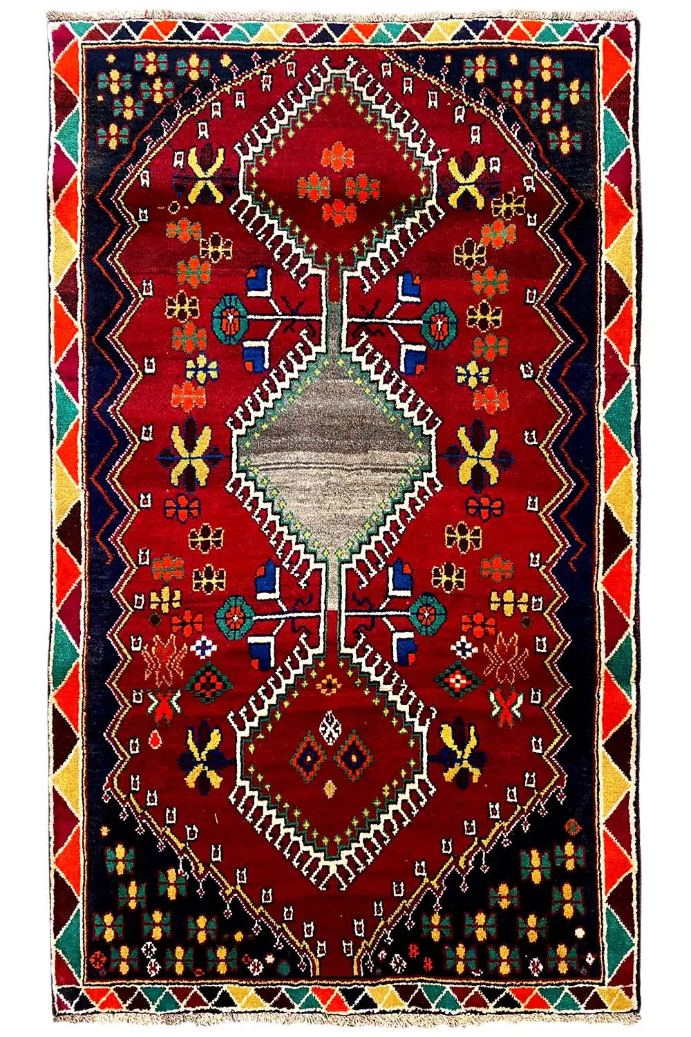 Rug with a red central medallion, multicolored ornaments, and a bordered edging