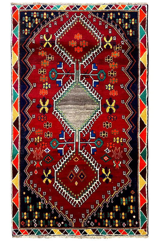 Rug with a red central medallion, multicolored ornaments, and a bordered edging