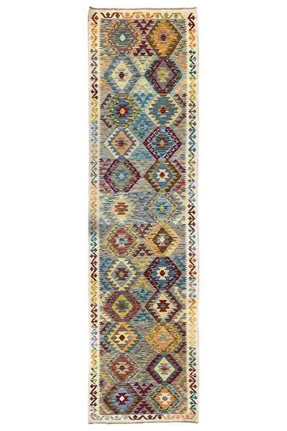 Rectangular kilim runner with diamond and zigzag patterns in blue, red, and yellow on a light background.