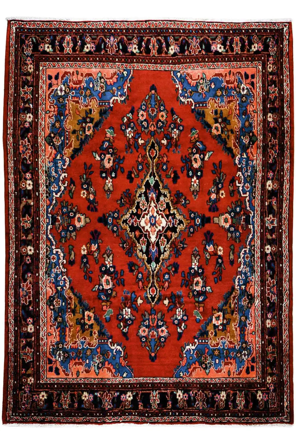 Oriental rug with a red central field, blue medallion, and finely patterned border