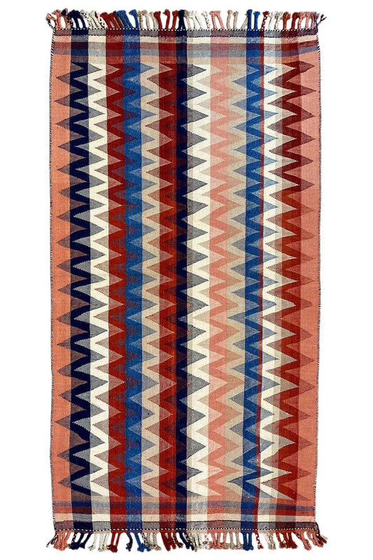 Rectangular rug with a geometric zigzag pattern in brown, blue, red, and beige, with fringes