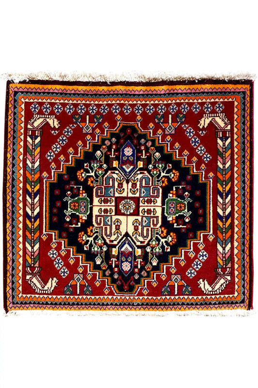 Square Oriental rug with a black center, burgundy border, and symmetrical ornamental pattern