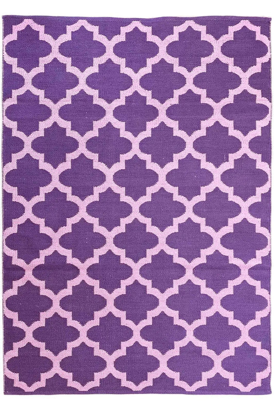 Rectangular rug with a purple background and a geometric quarter-flower pattern in violet