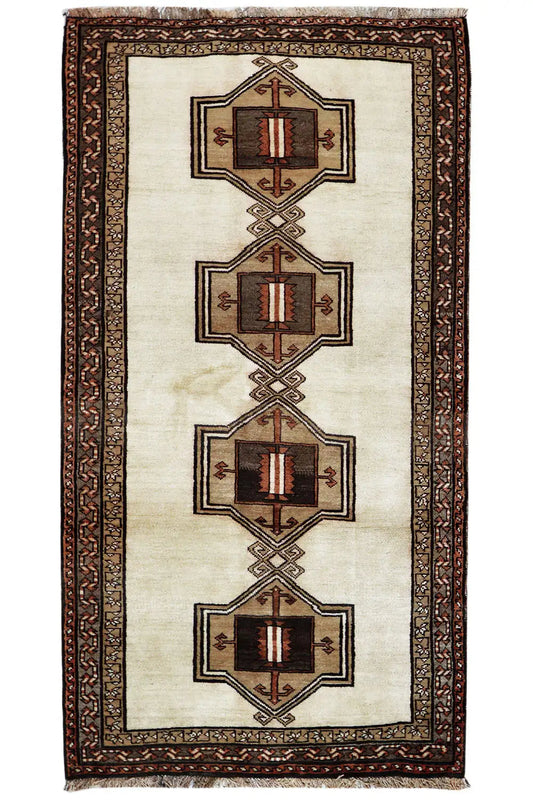 Oriental rug with a beige field, brown decorative border, and four medallions in a row.