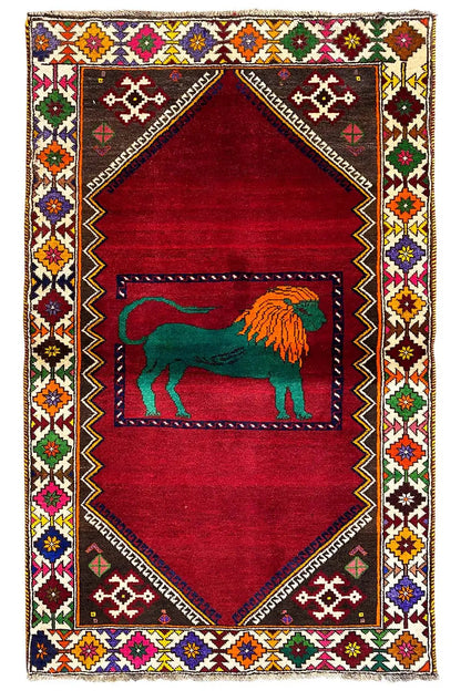 Gabbeh rug with a red background, a central lion motif, and a colorful ornamental border