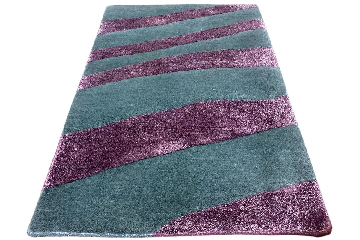 Rectangular rug with diagonally placed petrol-green and purple stripes