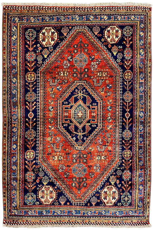 Oriental rug with a red central field, blue border, and floral ornaments
