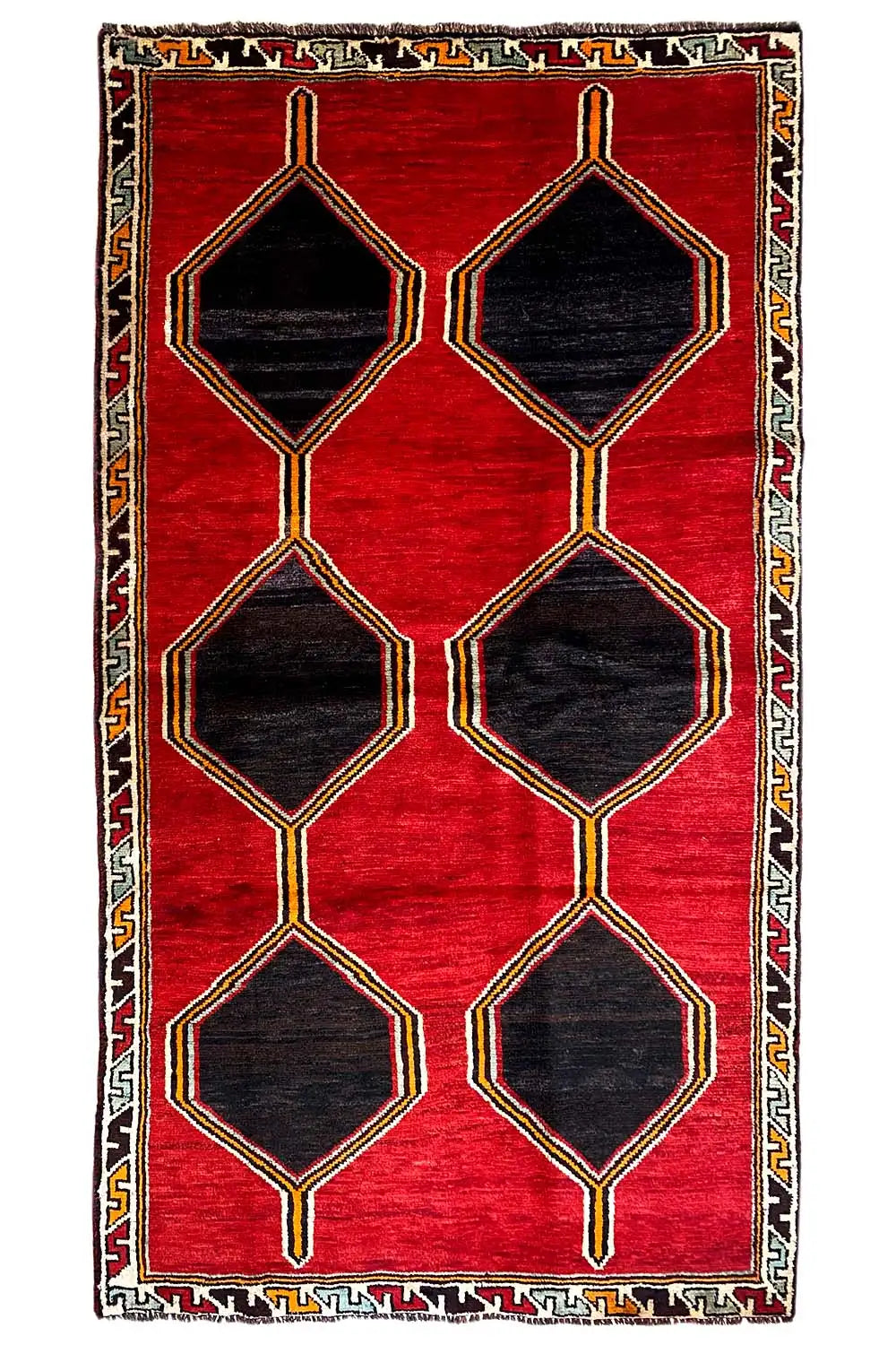 Red lori rug with stacked hexagons in black, gold-colored line border