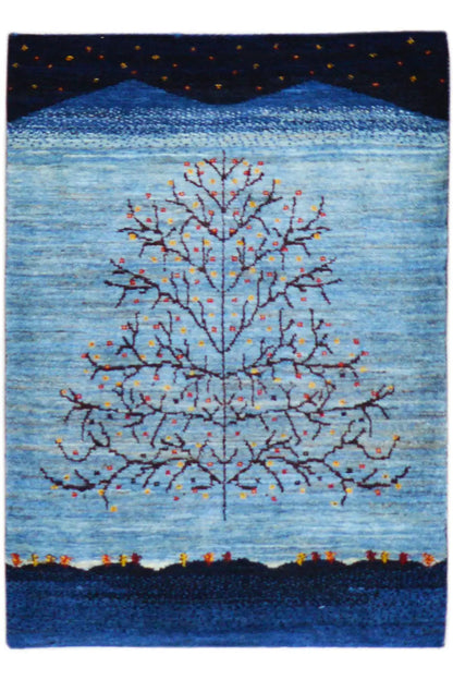 Gabbeh rug with a blue background, tree motif, and colorful accents, square