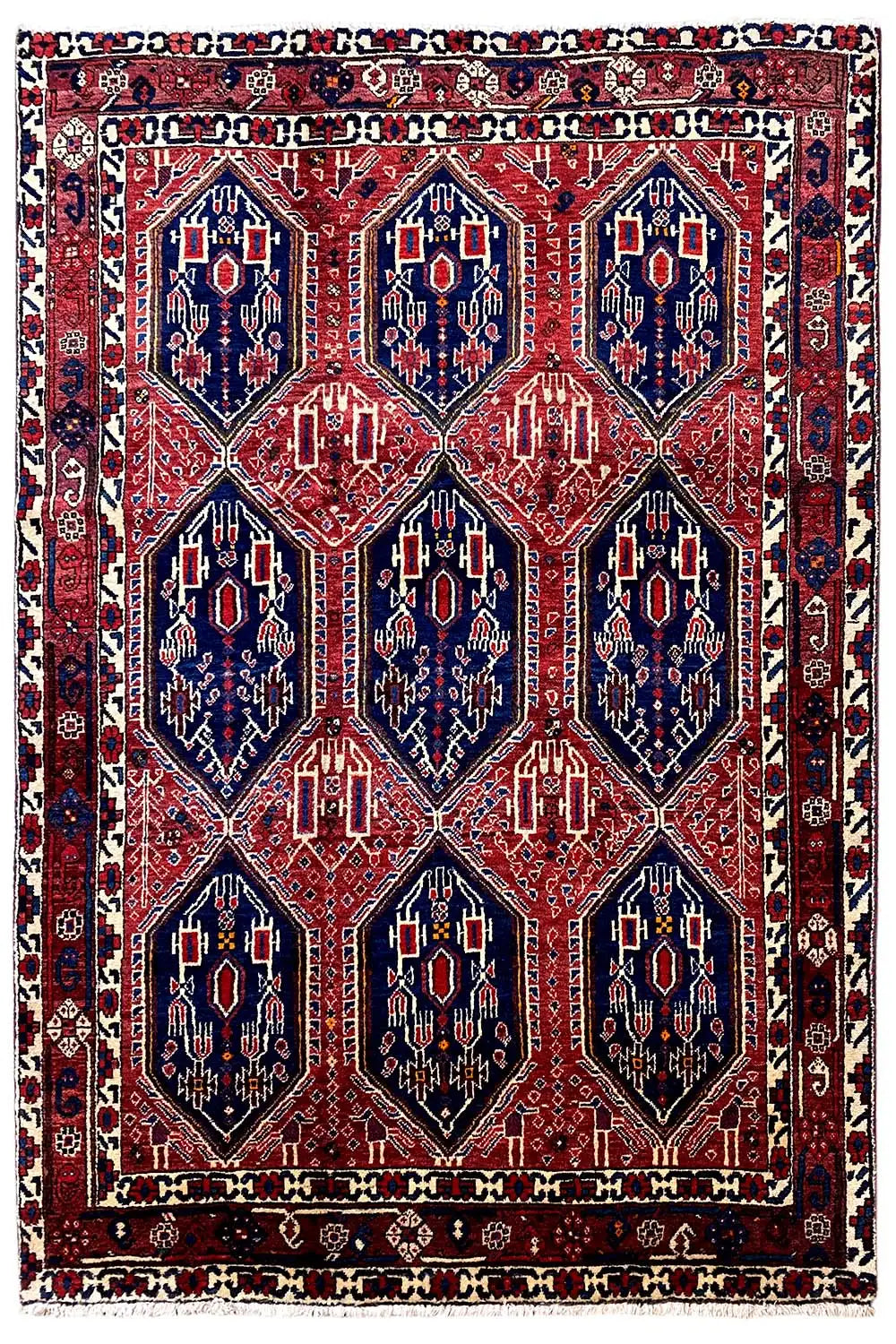 Rectangular Oriental rug with a red background and dark blue medallions