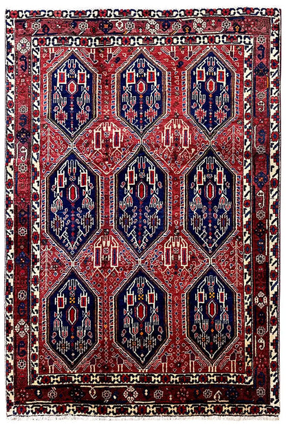 Rectangular Oriental rug with a red background and dark blue medallions