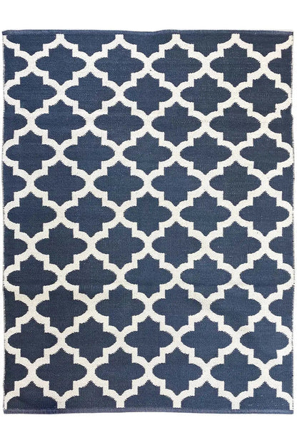 Rectangular kilim rug with a dark blue background and white quatrefoil diamond pattern