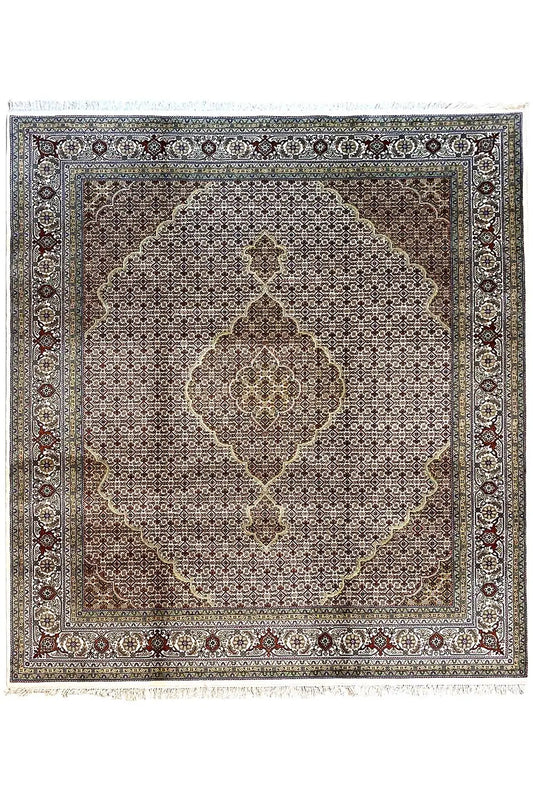 Rug with a square medallion, dark background, and ornamental border in blue and beige