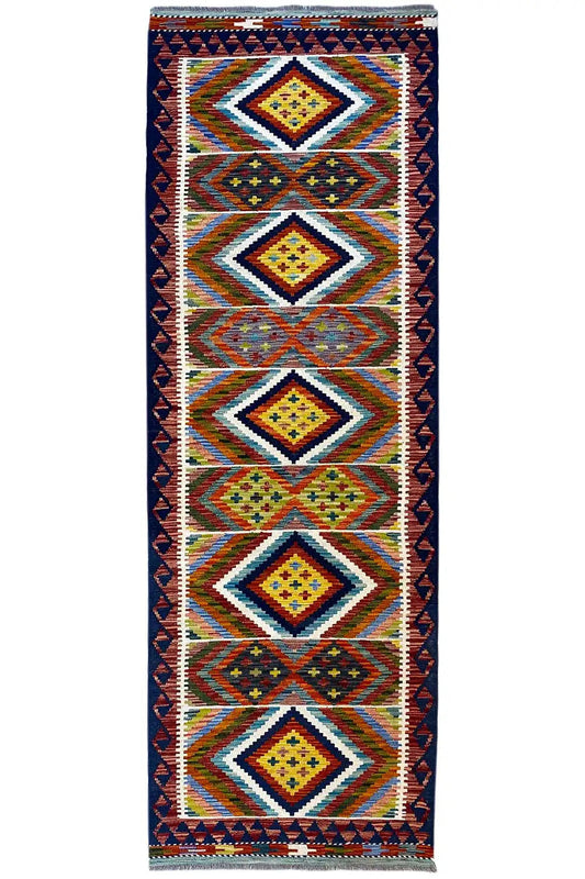 Kilim runner with geometric diamonds, a dark blue background and colorful blocks of color