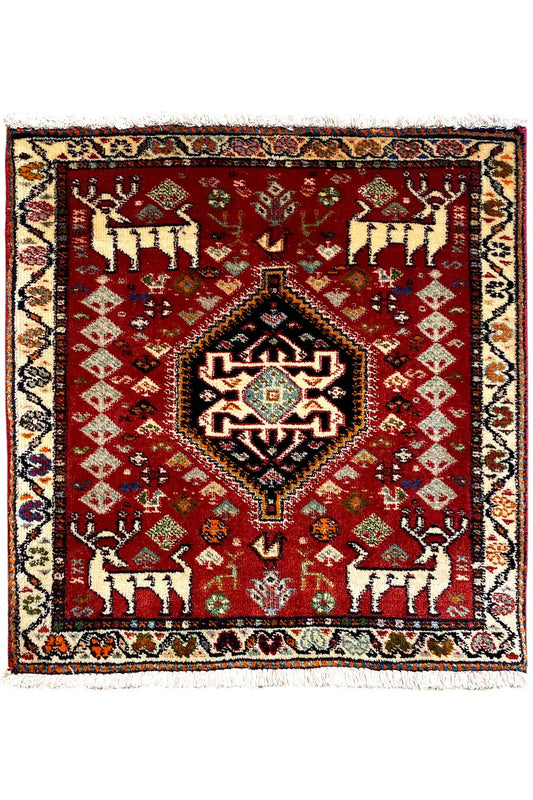 Square red rug with a central medallion, defined border, and fringes