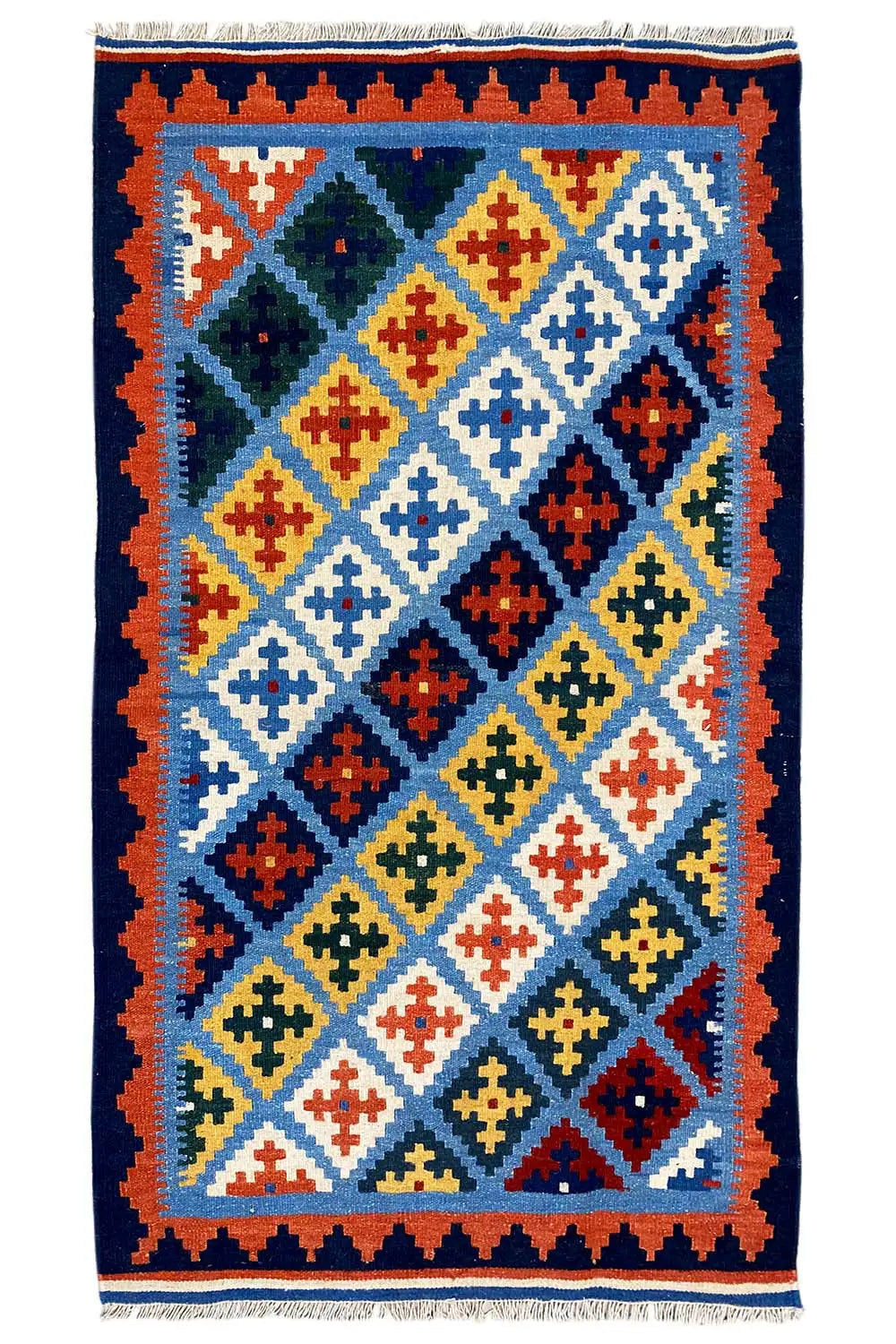 Kilim rug with a blue background, multicolored diagonals and diamonds, fringes