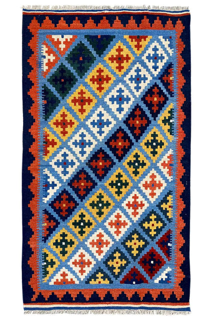 Kilim rug with a blue background, multicolored diagonals and diamonds, fringes