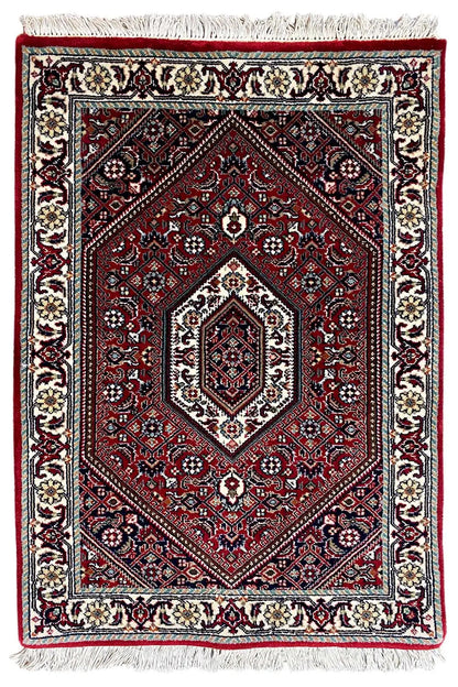 Rug (92x60 cm), red with medallion pattern and cream-colored borders, fringes