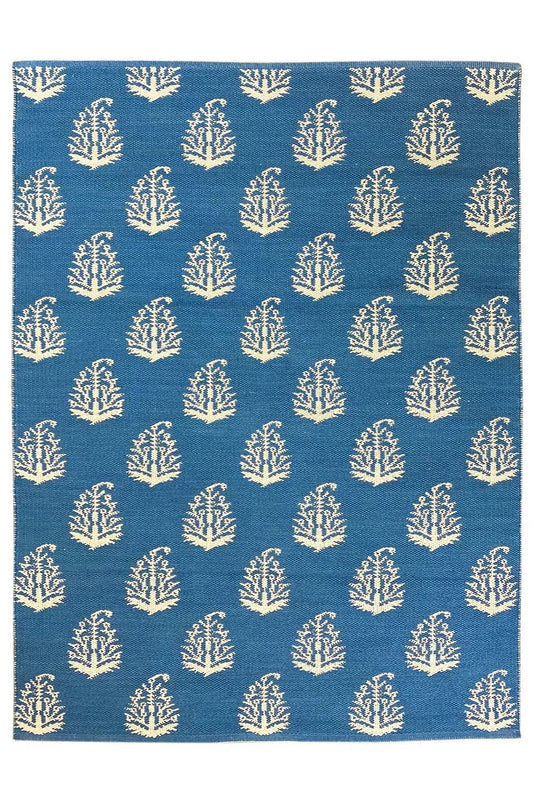 Blue kilim, square rug with repeated tree/branch motifs in cream.