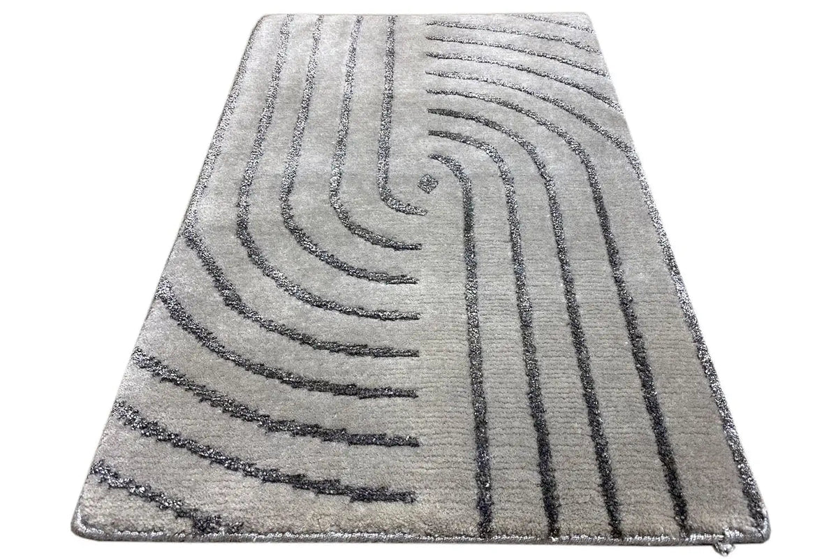 Rectangular rug with gray pile and a dark arched line pattern