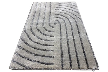 Rectangular rug with gray pile and a dark arched line pattern