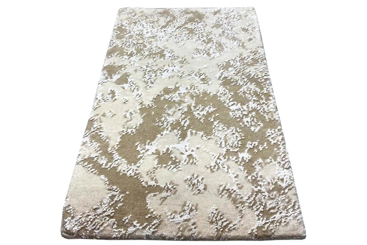 Designer rug, beige pile with a white abstract pattern, angled view, 60x40 cm