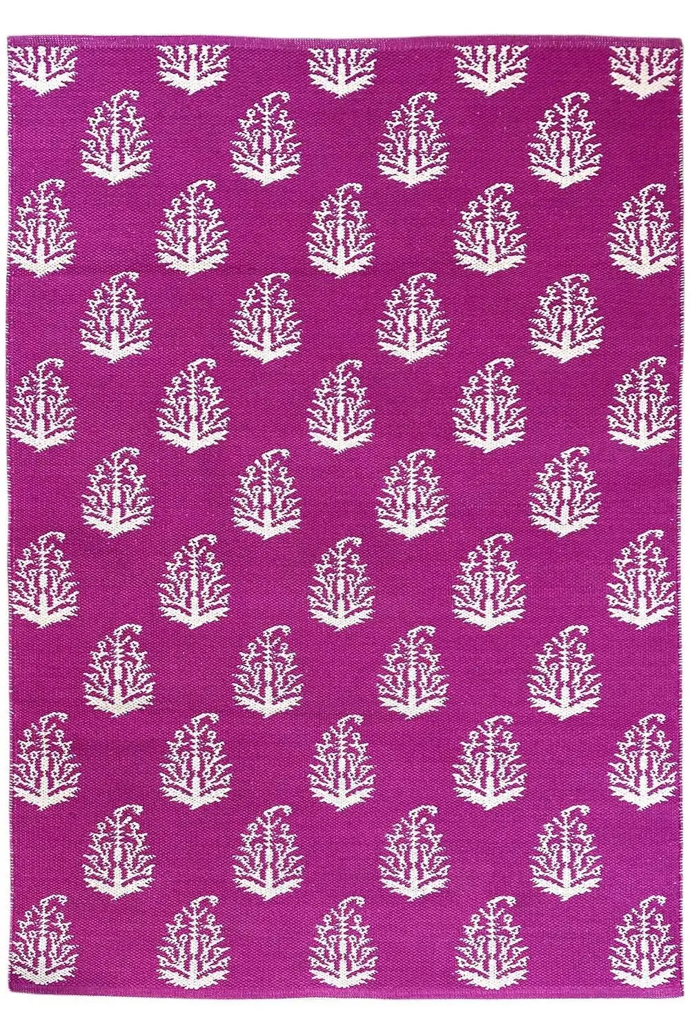 Modern flat-weave rug with purple fabric and white tree ornaments, flat lay