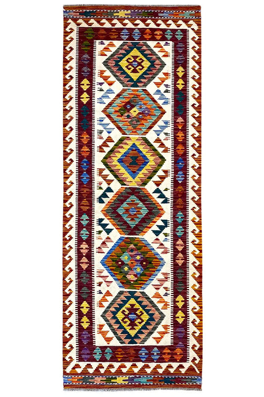 Afghan kilim runner with a colorful geometric pattern, border, and fringes