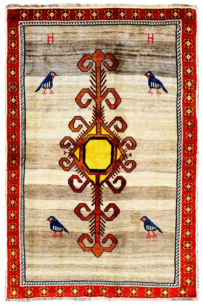 Gabbeh rug with a beige background, red border, and central medallion with an ornamental tree