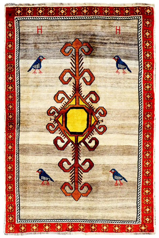 Gabbeh rug with a beige background, red border, and central medallion with an ornamental tree