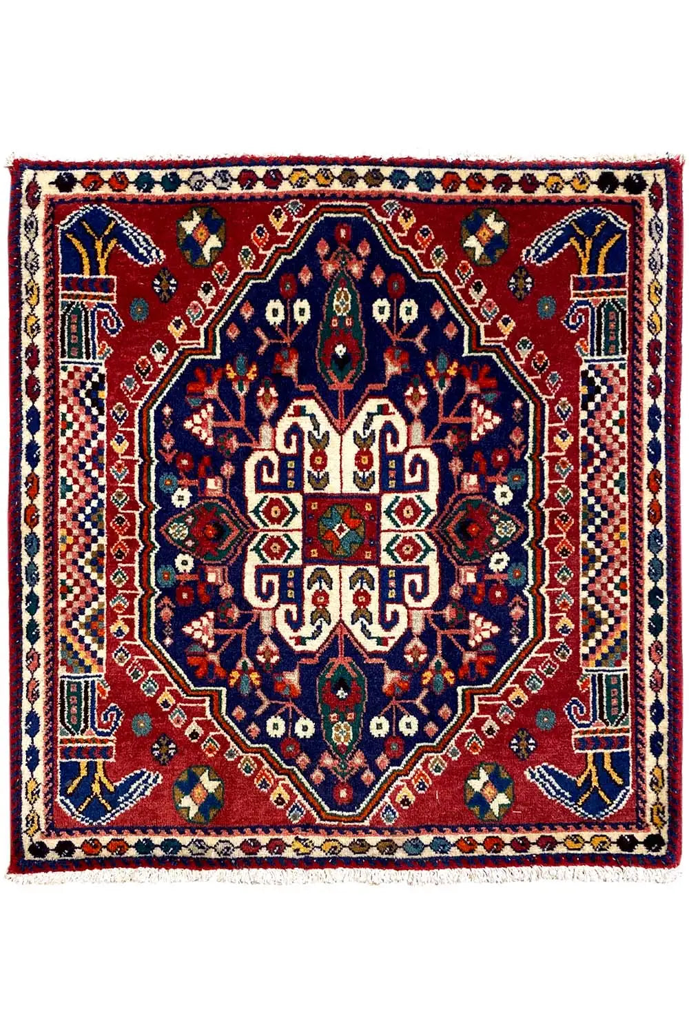 Square Oriental rug with a red field, blue central medallion, and border frame