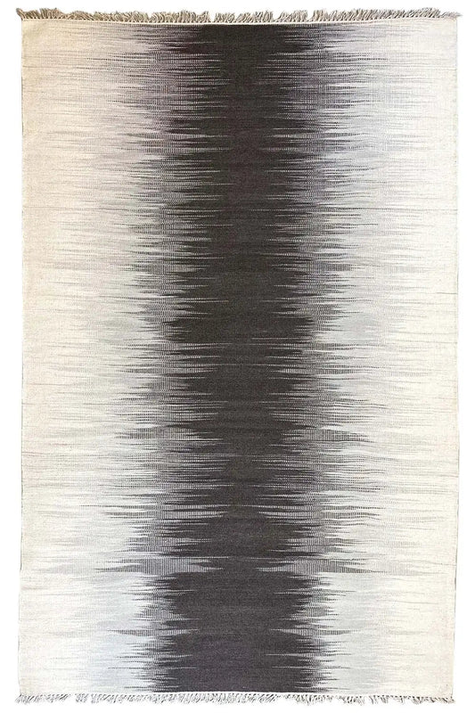 Rectangular gray kilim rug with dark gradient patterns and fringes along the edge