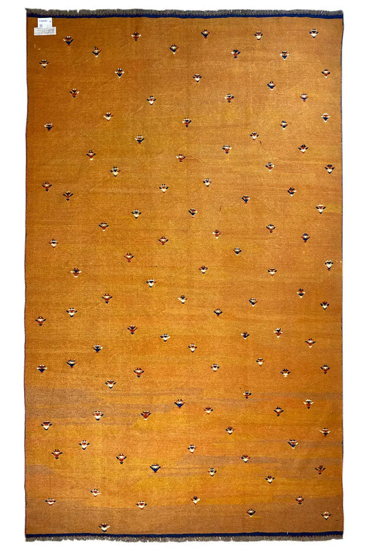 Rectangular oriental rug, warm brown-orange with small multicolored patterns and blue edging.