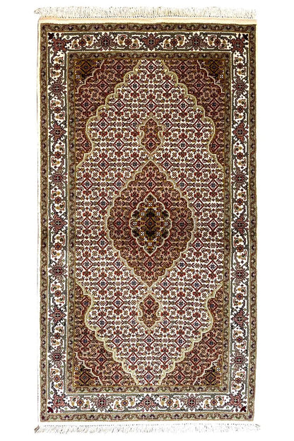 Indo Tabriz rug: rectangular, dark red-brown medallion with a white vine pattern.