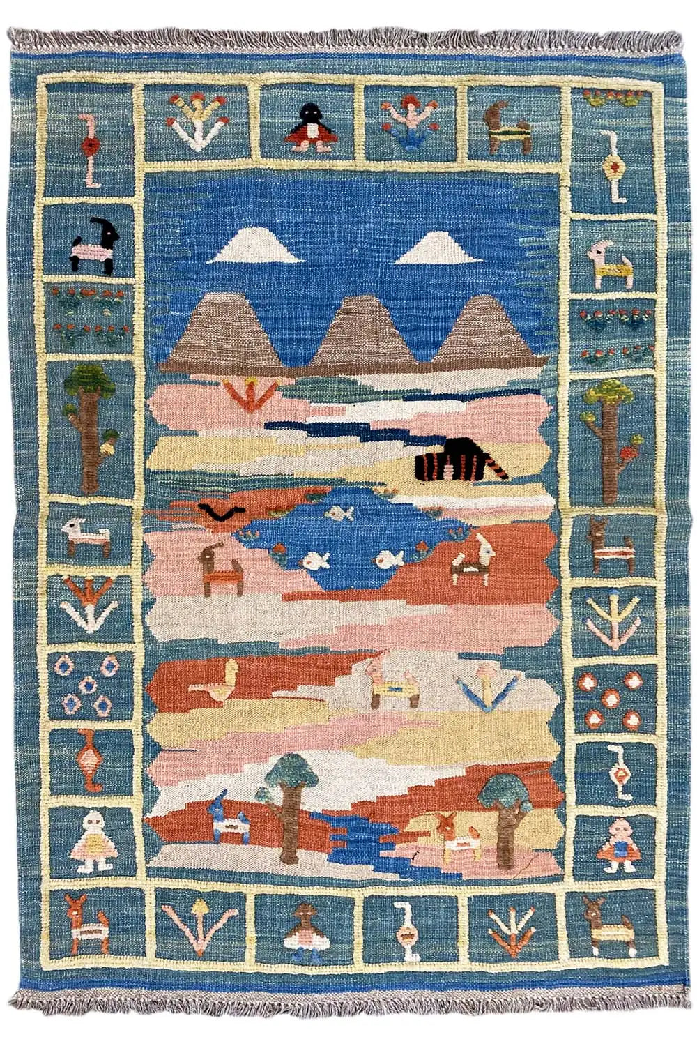 Kilim rug shown straight on, slightly offset: blue, red and beige with a figural border and fringes