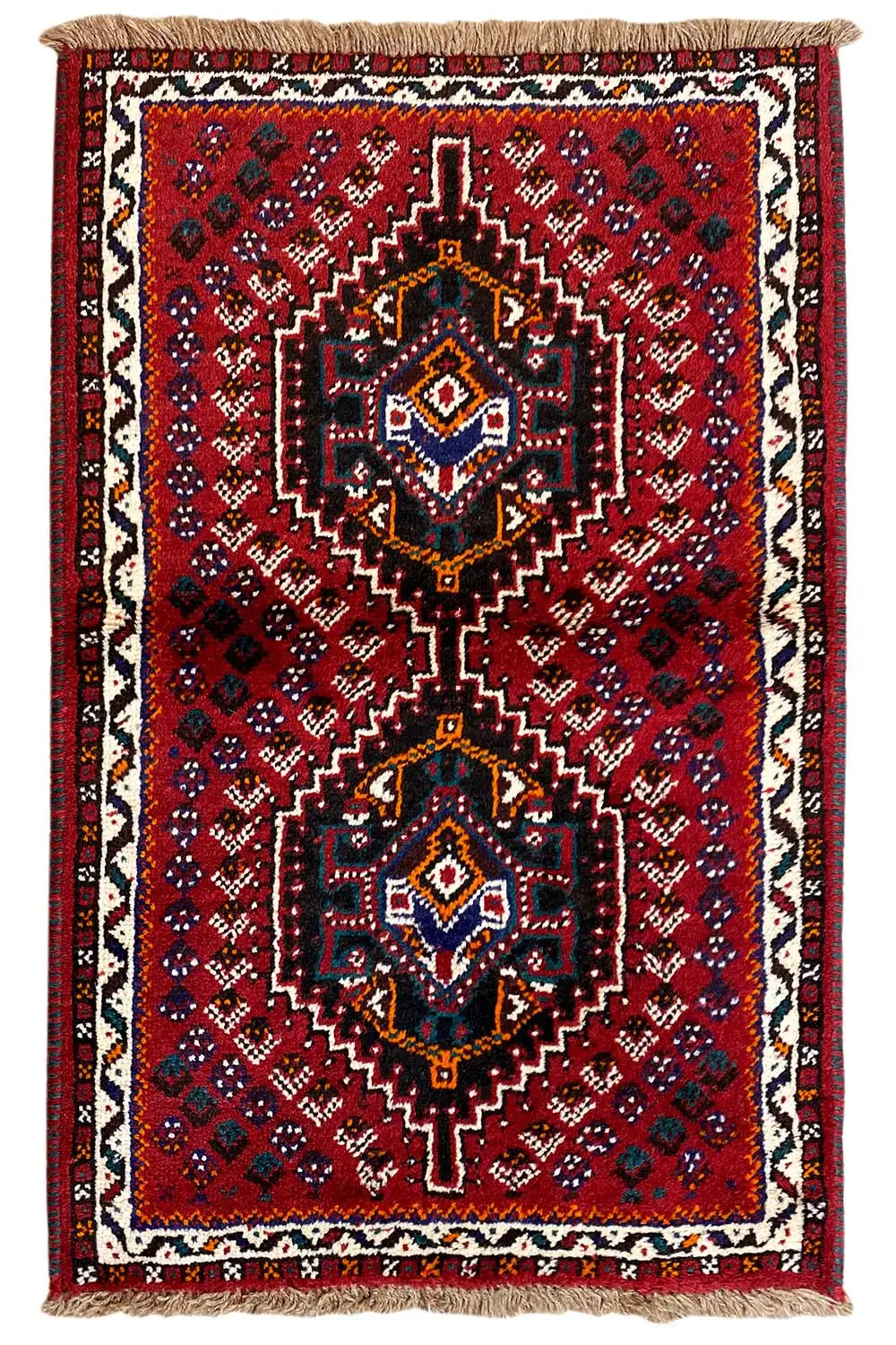 Rectangular oriental rug: red field, central medallions, fringes at the top and bottom