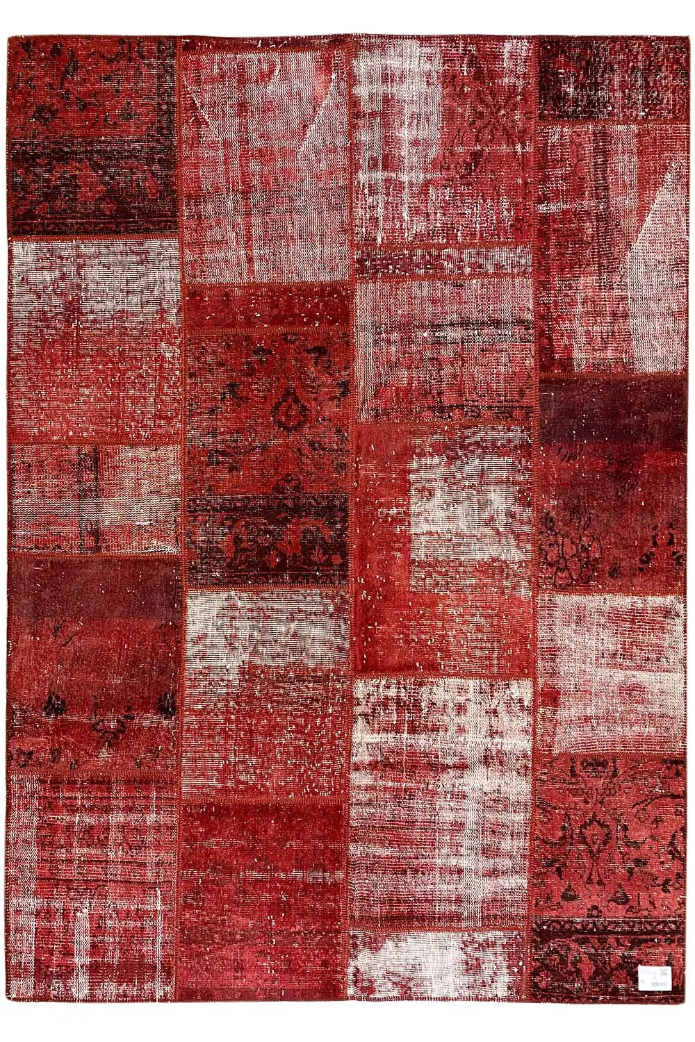 Rectangular patchwork rug, red and white, with varied patchwork pieces and ornamental inserts