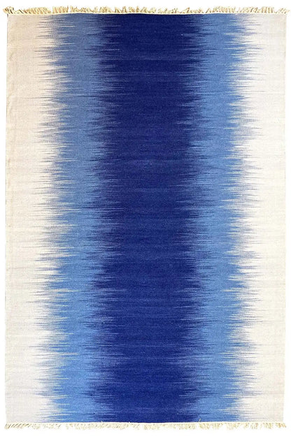 Rectangular kilim dhurrie rug in light beige with a blue central area and fringes