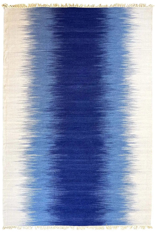 Rectangular kilim dhurrie rug in light beige with a blue central area and fringes