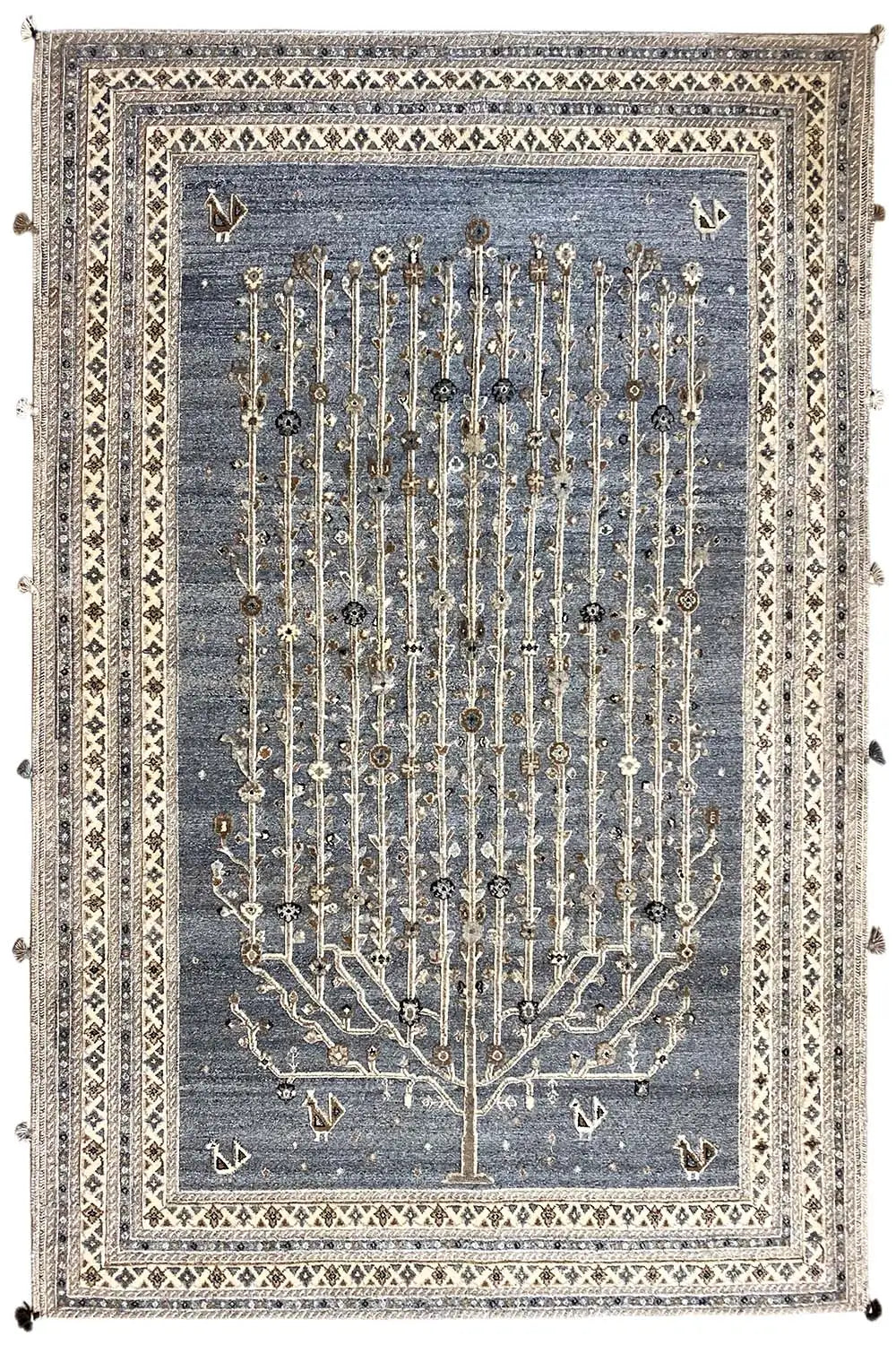Rug with a blue-gray background, a gold-colored tree relief, and a decorative border with tassels