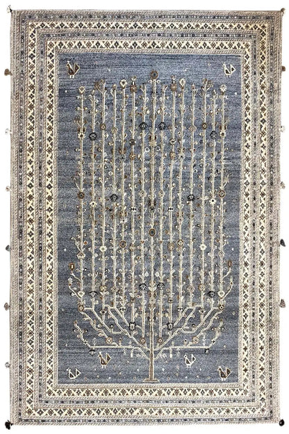 Rug with a blue-gray background, a gold-colored tree relief, and a decorative border with tassels