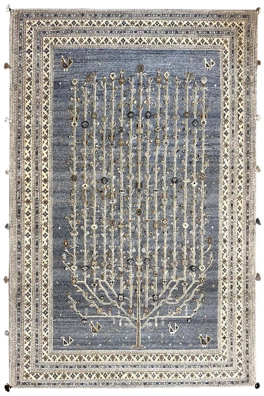 Rug with a blue-gray background, a gold-colored tree relief, and a decorative border with tassels