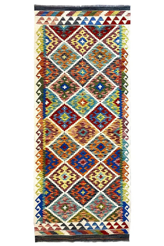 Afghan runner with a geometric pattern in blue, red, green, and yellow, with fringes